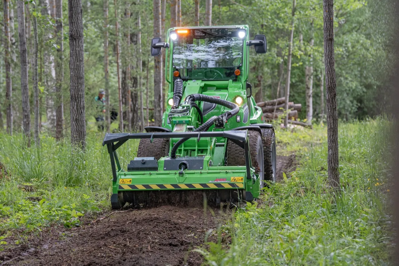 A tracked forestry mulcher grinding brush along a wooded trail in southern Wisconsin